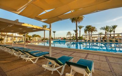 Sun loungers and shaded terrace by the pool at El Mouradi Port El Kantaoui Sun loungers and shaded terrace by the pool at El Mouradi Port El Kantaoui