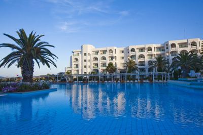 Swimming pool reflecting the hotel building at El Mouradi Mahdia