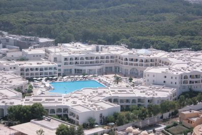 Aerial view of the hotel and pool surrounded by forest at El Mouradi Gammarth Aerial view of the hotel and pool surrounded by forest at El Mouradi Gammarth