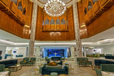 Hotel lobby with chandelier and lounge seating at El Mouradi Palace Hotel lobby with chandelier and lounge seating at El Mouradi Palace