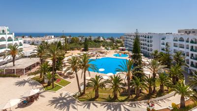 Swimming pool, palm trees and sea view from above at El Mouradi Palace Swimming pool, palm trees and sea view from above at El Mouradi Palace