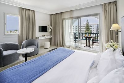 Superior room with balcony and blue bed runner at El Mouradi Palace Superior room with balcony and blue bed runner at El Mouradi Palace